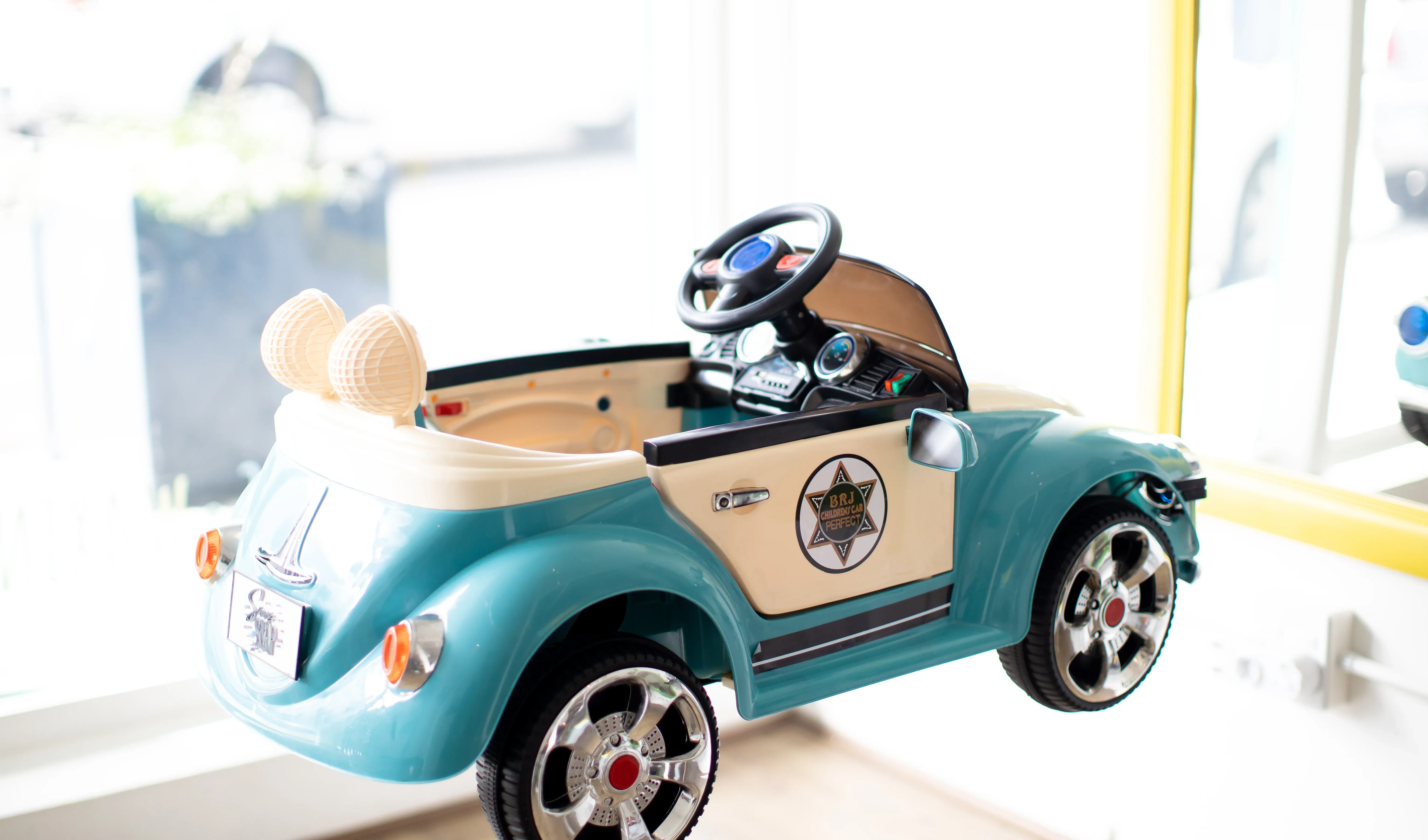 The teal toy car chair — kids sit in it for their haircut at Snip Snap Salon